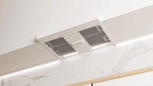 Miljöbild på Innohome spisvakt EVO sensor som fästs vid en köksfläkt för att kunna aktiveras vid överhettning på en spis.